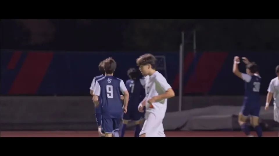 La Salle soccer players celebrating a goal under the lights.